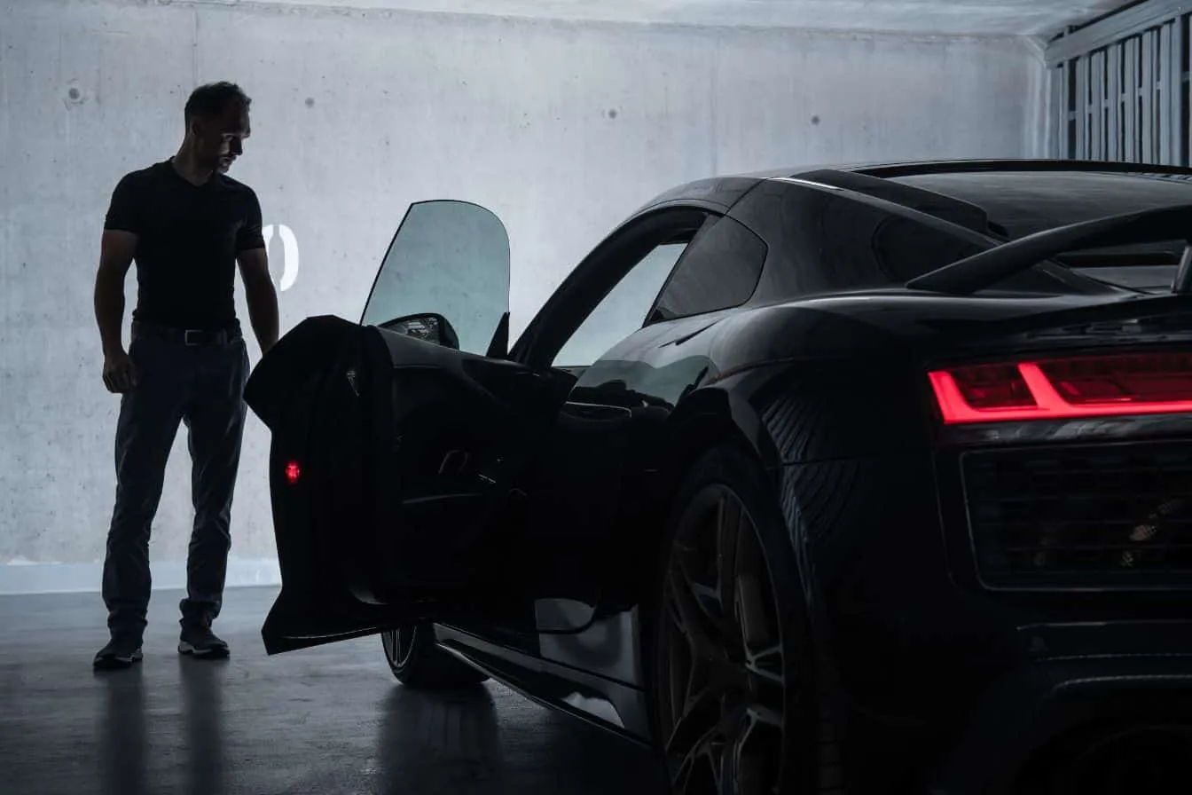 meilleure-voiture-sportive Homme devant une voiture sportive noire