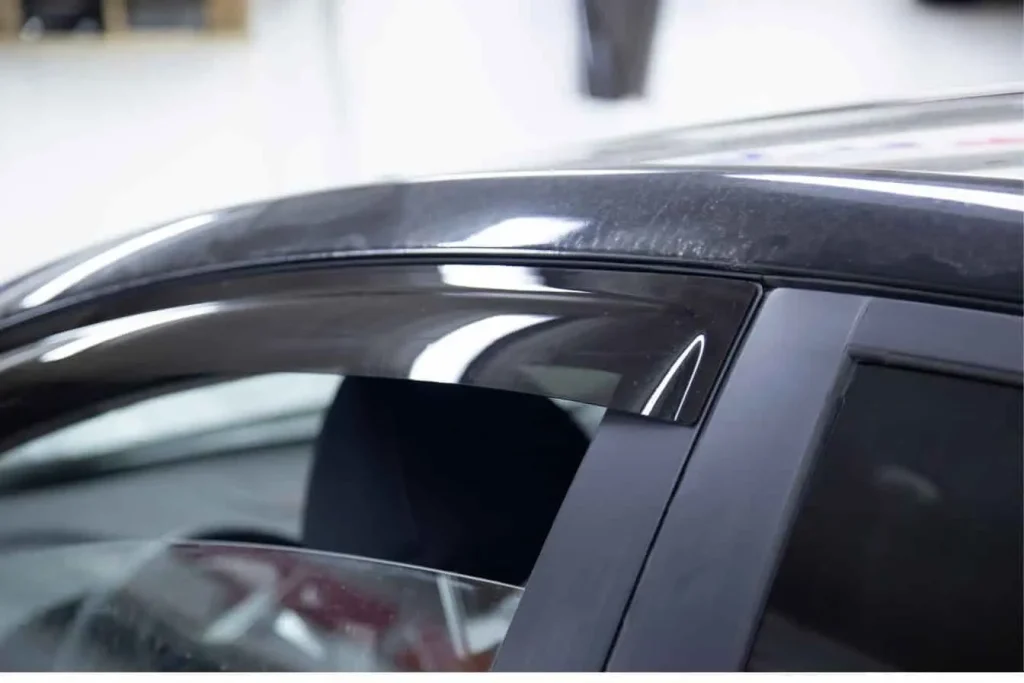 Déflecteur de capot noir installé sur une voiture.