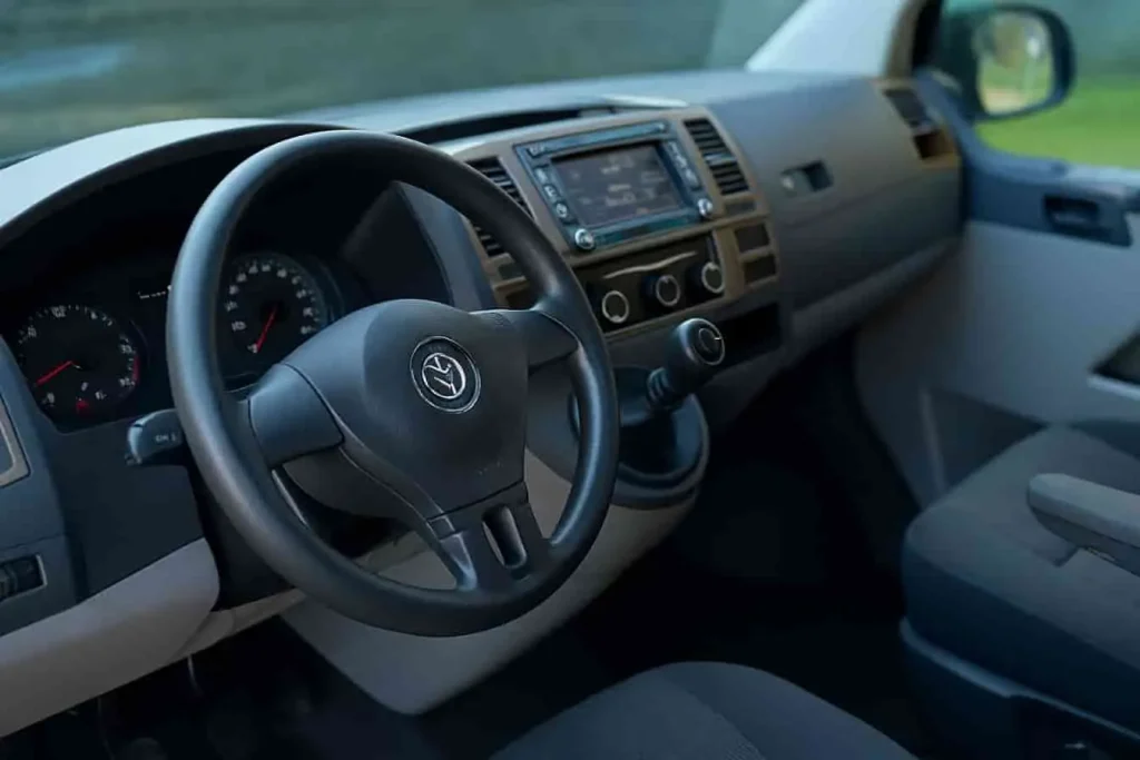 Intérieur du Volkswagen T5, volant logo VW, tableau de bord moderne et finitions sobres, pensé pour les pros exigeants.