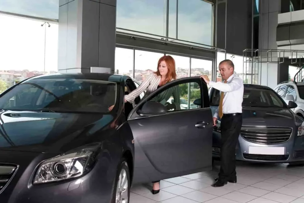 Dialogue entre deux personnes autour d’un véhicule : illustration d’une négociation dans l’achat-revente auto.