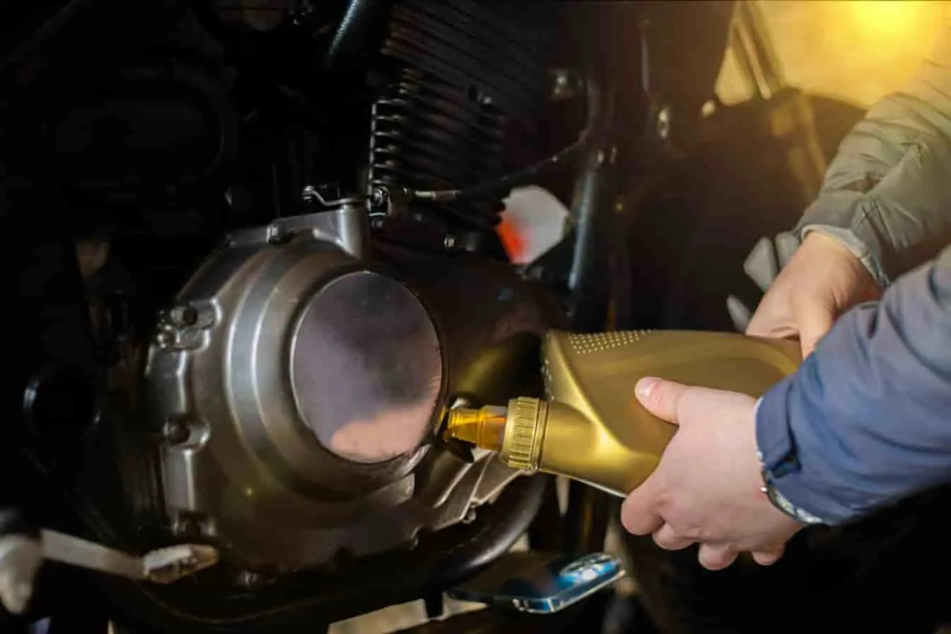 Versement d’huile moteur dans une moto Entretien moto en cours : l’usage de la meilleure huile moteur assure une protection optimale du moteur.