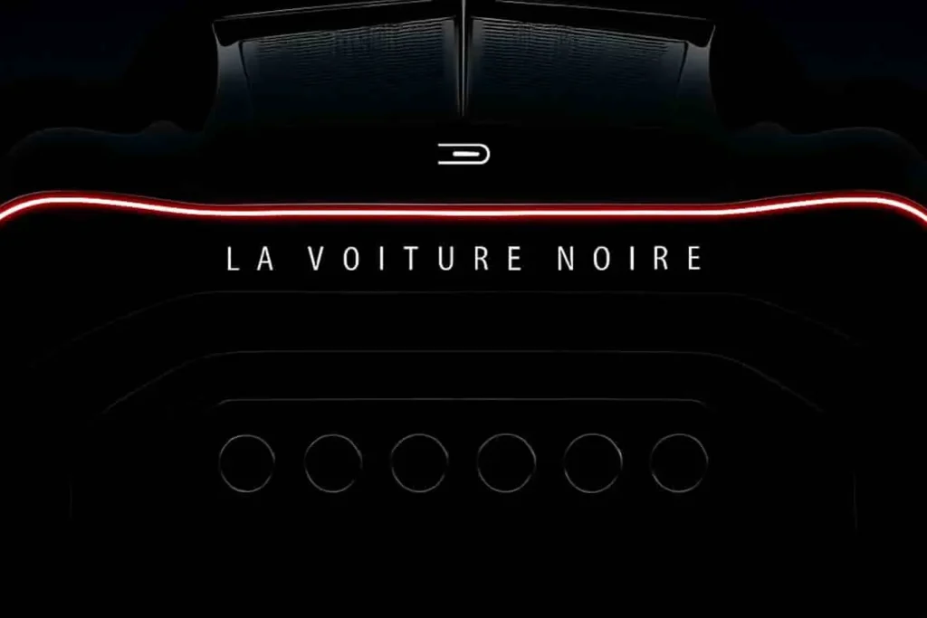 Vue arrière de Bugatti La Voiture Noire avec six échappements alignés, LED rouge et design noir sculpté sur fond sombre.