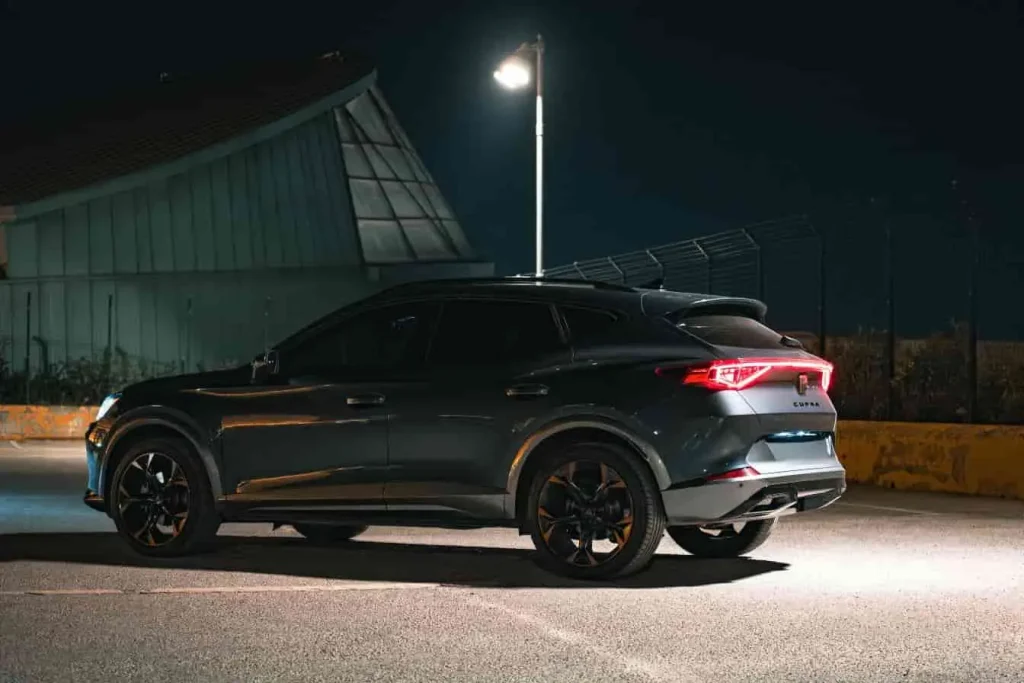 SUV Cupra Formentor stationné sous lumière artificielle, design racé et ambiance nocturne.