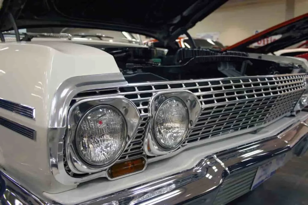 Voiture vintage blanche exposée, évoquant l’univers de Supernatural et l’Impala de Dean Winchester par son style rétro et ses lignes puissantes.
