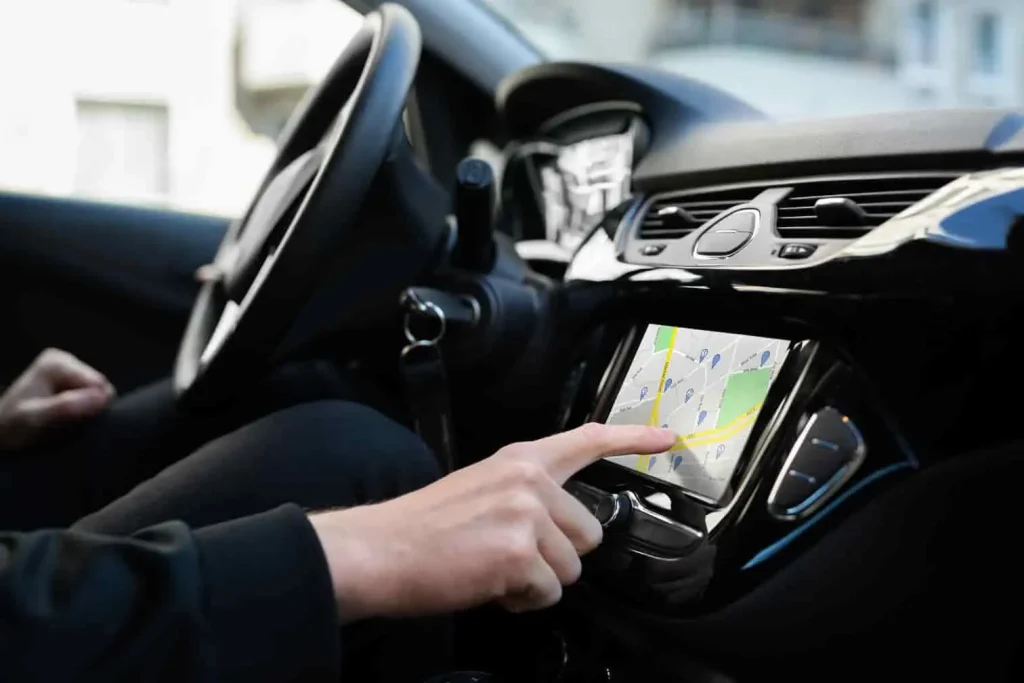 Conducteur tentant de recalibrer l’itinéraire sur écran tactile, image liée à un bug de guidage Waze.