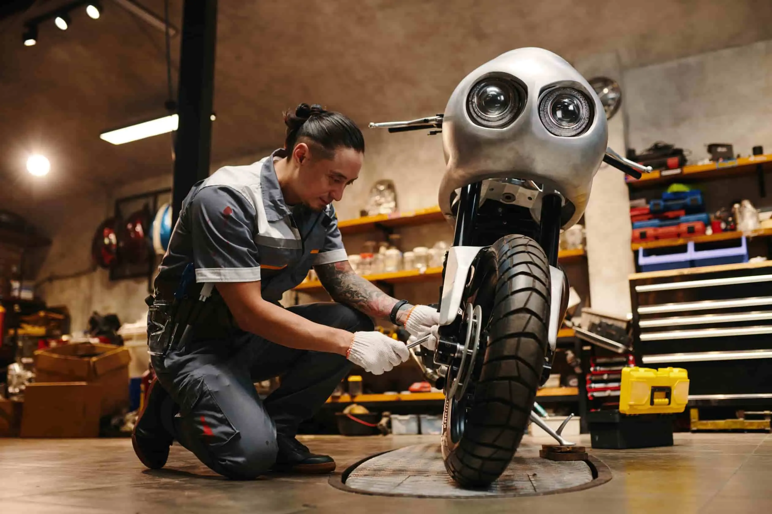 changer un embrayage moto Mécanicien agenouillé devant une moto, en pleine opération pour changer un embrayage, fond atelier.