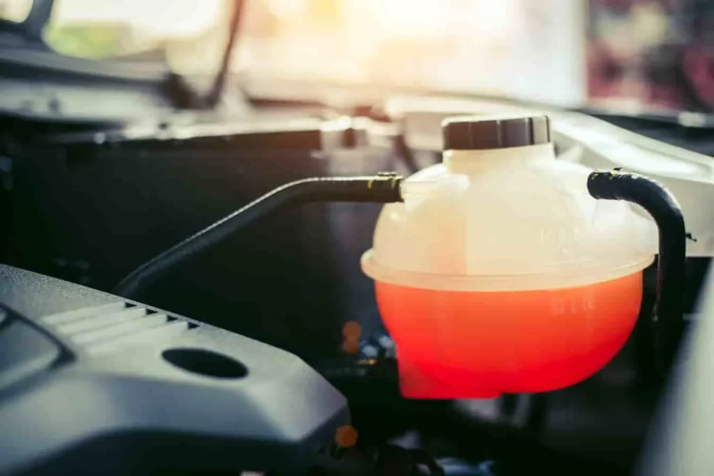 Liquide de refroidissement rouge visible dans le réservoir, scène évoquant la proportion idéale avec l’antigel