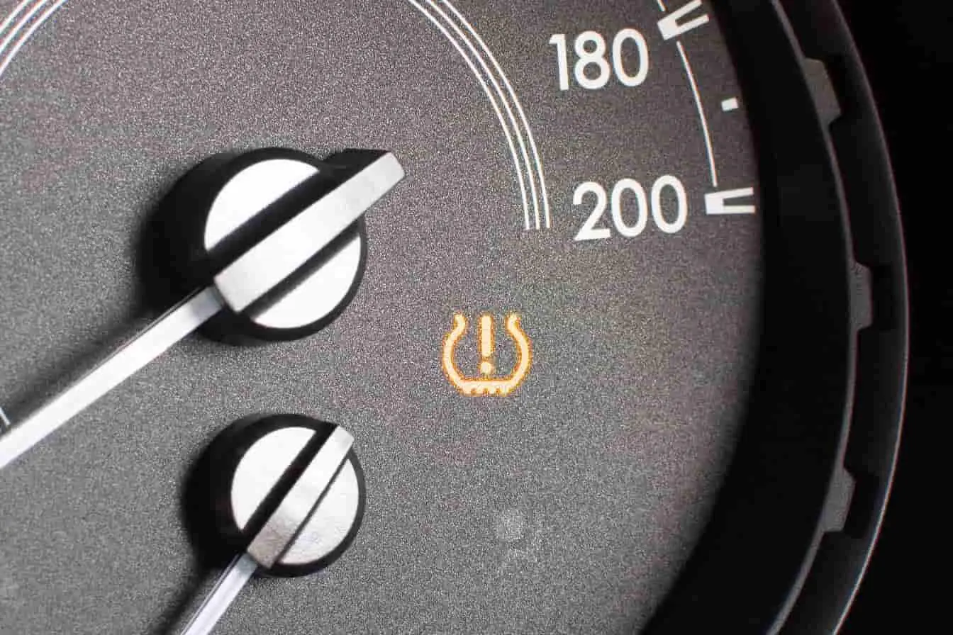 alerte de pression des pneus Compteur affichant une vitesse élevée avec voyant TPMS allumé, image illustrant une alerte de pression des pneus à vérifier