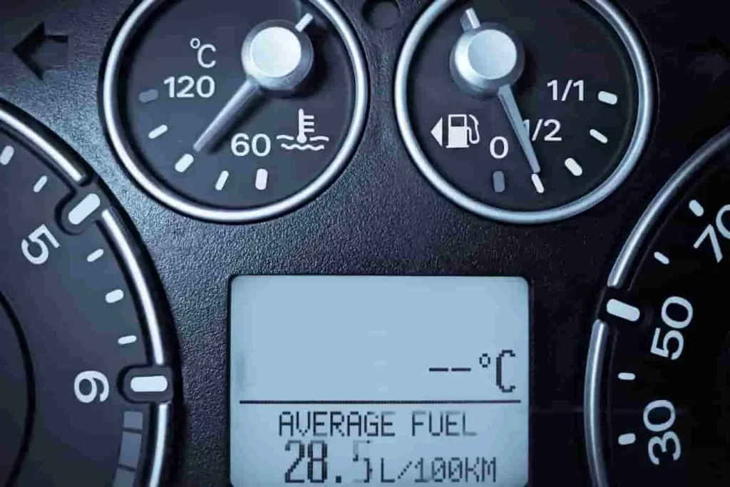 Consommation moyenne élevée sur écran digital, aiguille carburant en bas, signe d’un capteur d’arbre à cames possiblement défectueux
