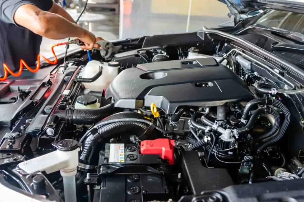 Mécanicien utilisant un outil pneumatique sur moteur ouvert, image illustrant une vérification suite à un recours vendeur pour défaut moteur