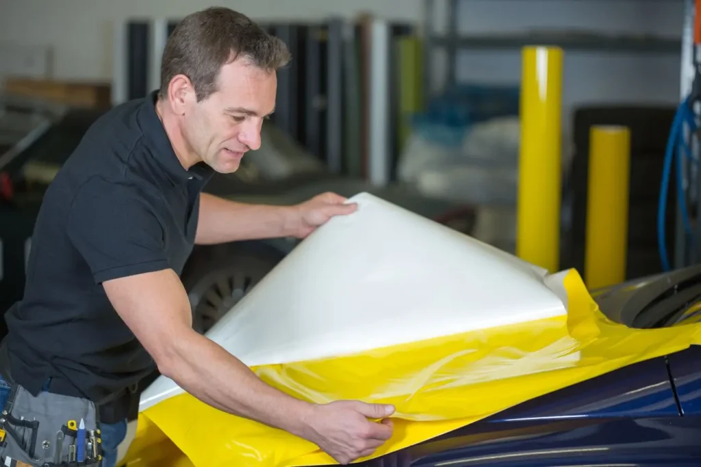 Film blanc et jaune ajusté sur capot sombre, image d’un covering réalisé pour résister dans le temps
