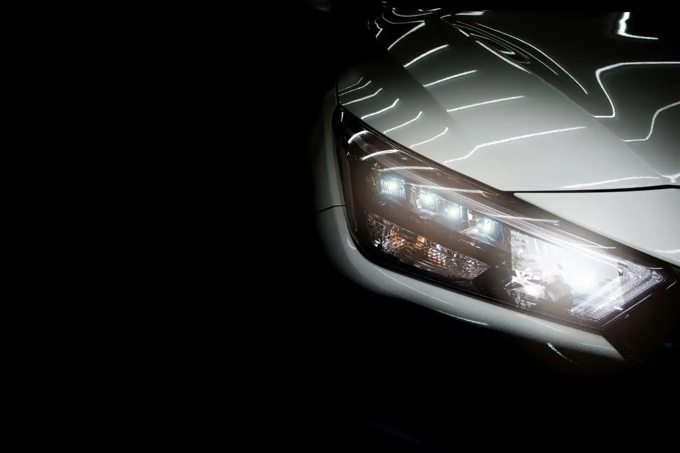 phares Gros plan sur phare LED allumé avec reflets lumineux, image d’un design automobile moderne et précis
