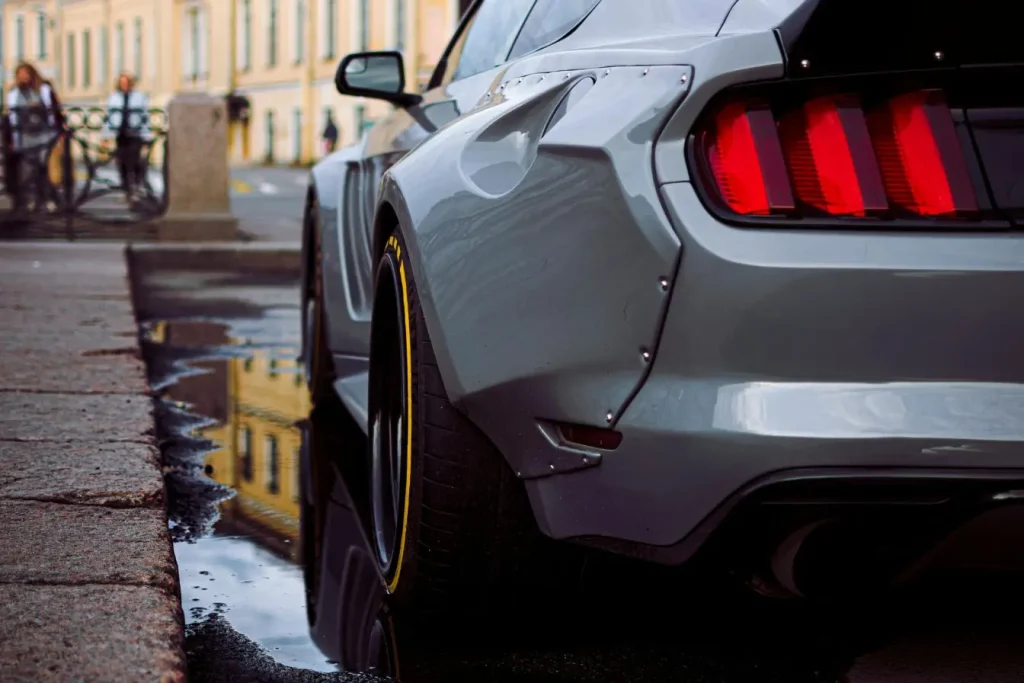 Ford Mustang Mach-E gris vue arrière avec ailes élargies et spoiler, image d’un SUV électrique au style radical