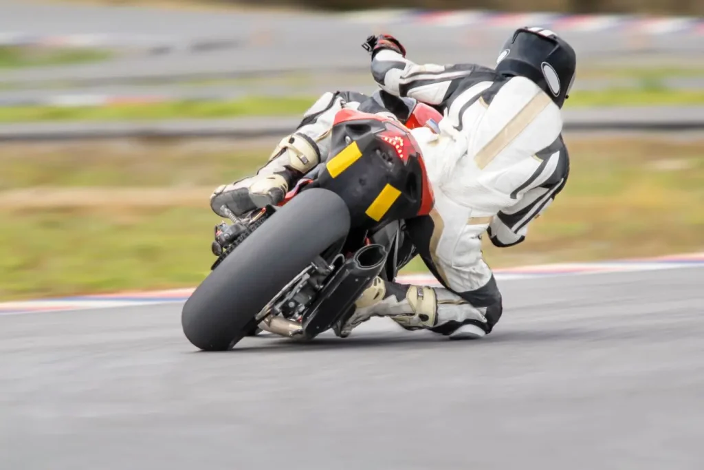 Pilote en combinaison racing noir et blanc sur moto sportive, image d’un style incisif à la Francesco Bagnaia