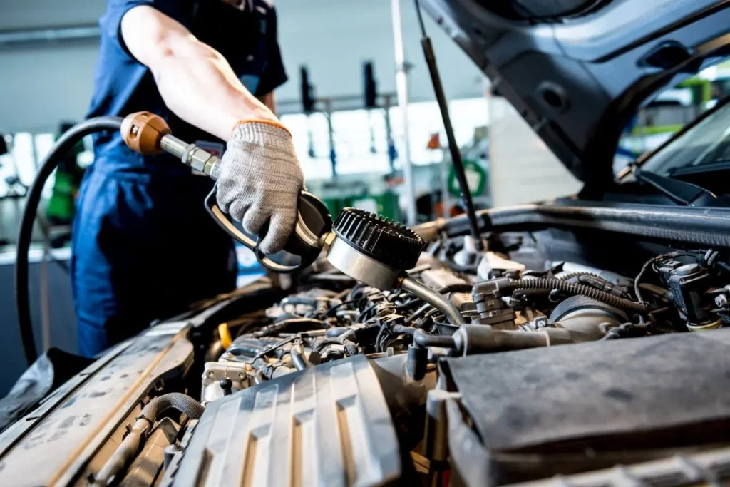 Crépine d'huile moteur en maille métallique, fixée au tuyau de ramassage, visible dans le carter d'huile du moteur d'une voiture