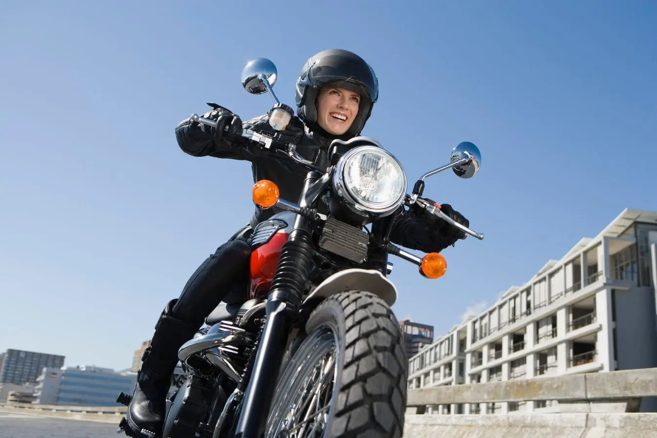 gilet airbag Motard en tenue noire sur moto urbaine, image illustrant l’efficacité d’un gilet airbag haut de gamme