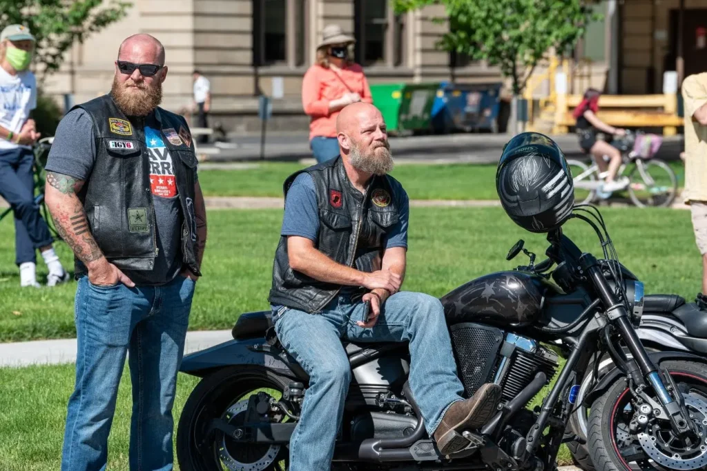 Deux motards en gilet cuir près d’une moto noire, ambiance inspection visuelle avant contrôle technique