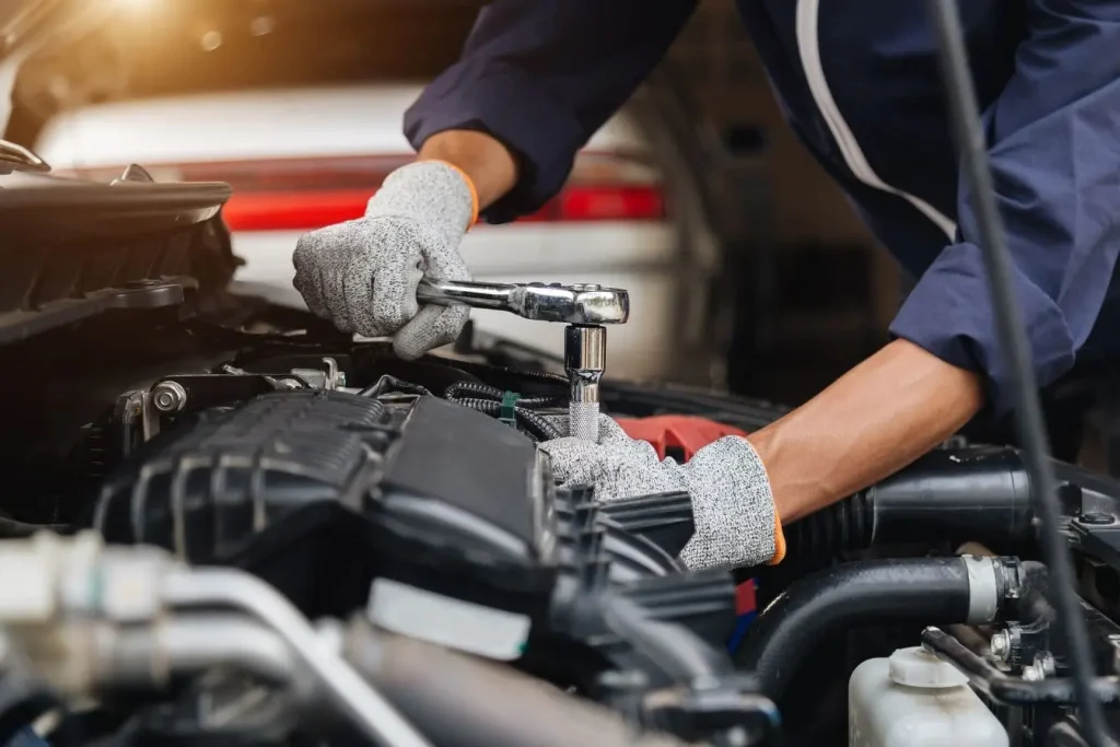 Mécanicien en bleu serrant un boulon sur le moteur d’un Scenic 3 1.6 dCi avec clé à cliquet