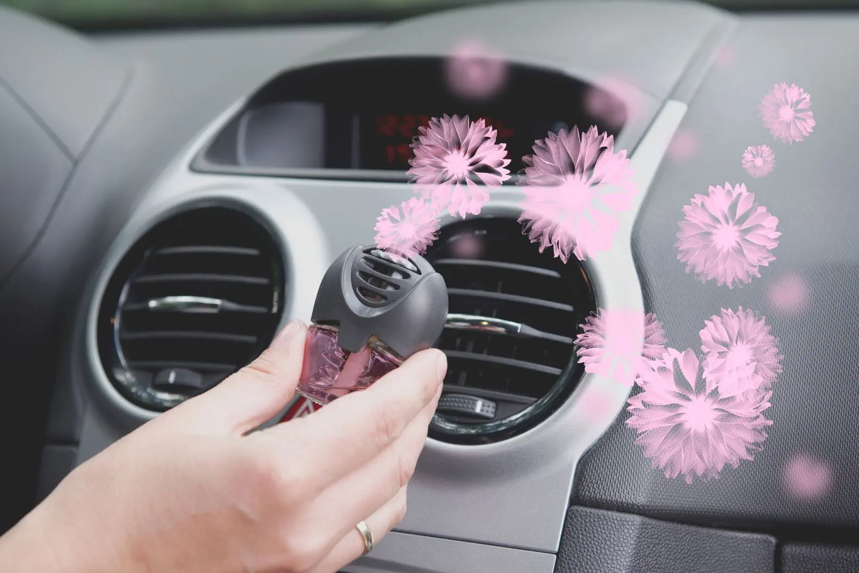 désodorisant voiture Désodorisant rose installé dans une grille d’aération, image d’un parfum voiture fait maison