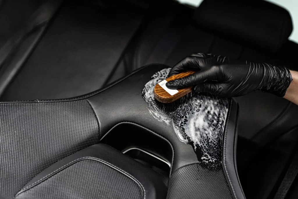 Mousse nettoyante appliquée sur cuir auto, image d’un soin intérieur pour préserver la matière