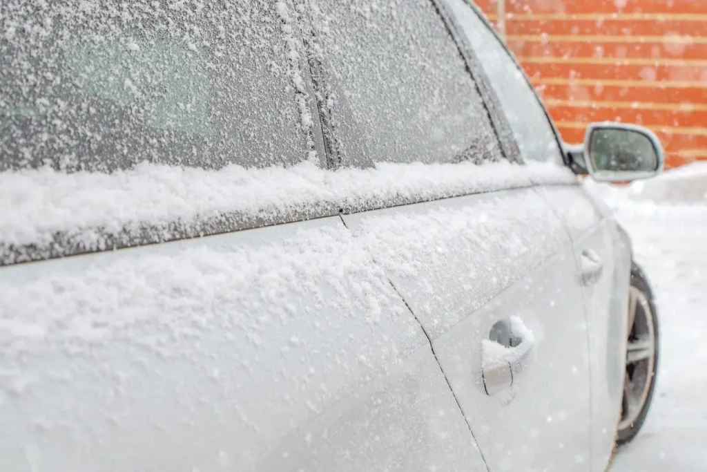 Voiture blanche recouverte de neige et glace sur carrosserie et vitres