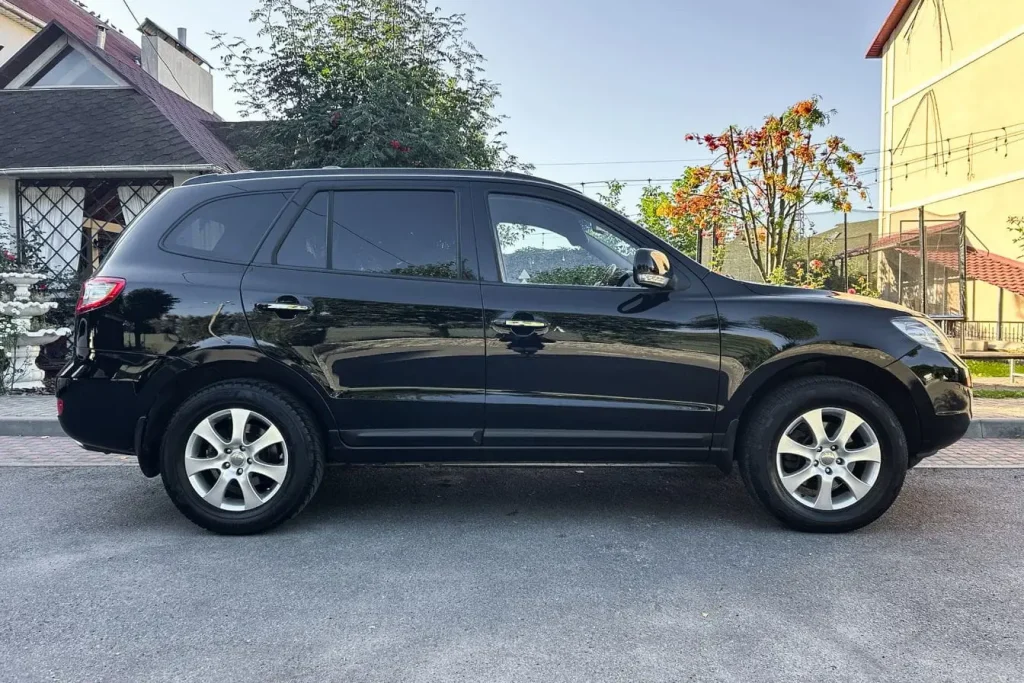 SUV noir garé en extérieur, profil complet visible avec marche-pied électrique facilitant l’accès et offrant confort moderne