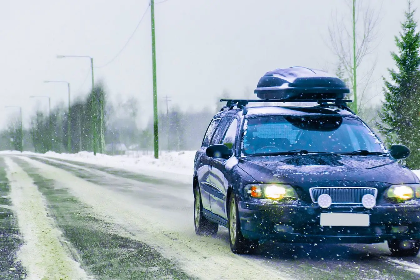 galerie de toit Voiture équipée d’un coffre de toit sur route hivernale, illustration d’une charge maximale sécurisée pour transporter bagages et équipements
