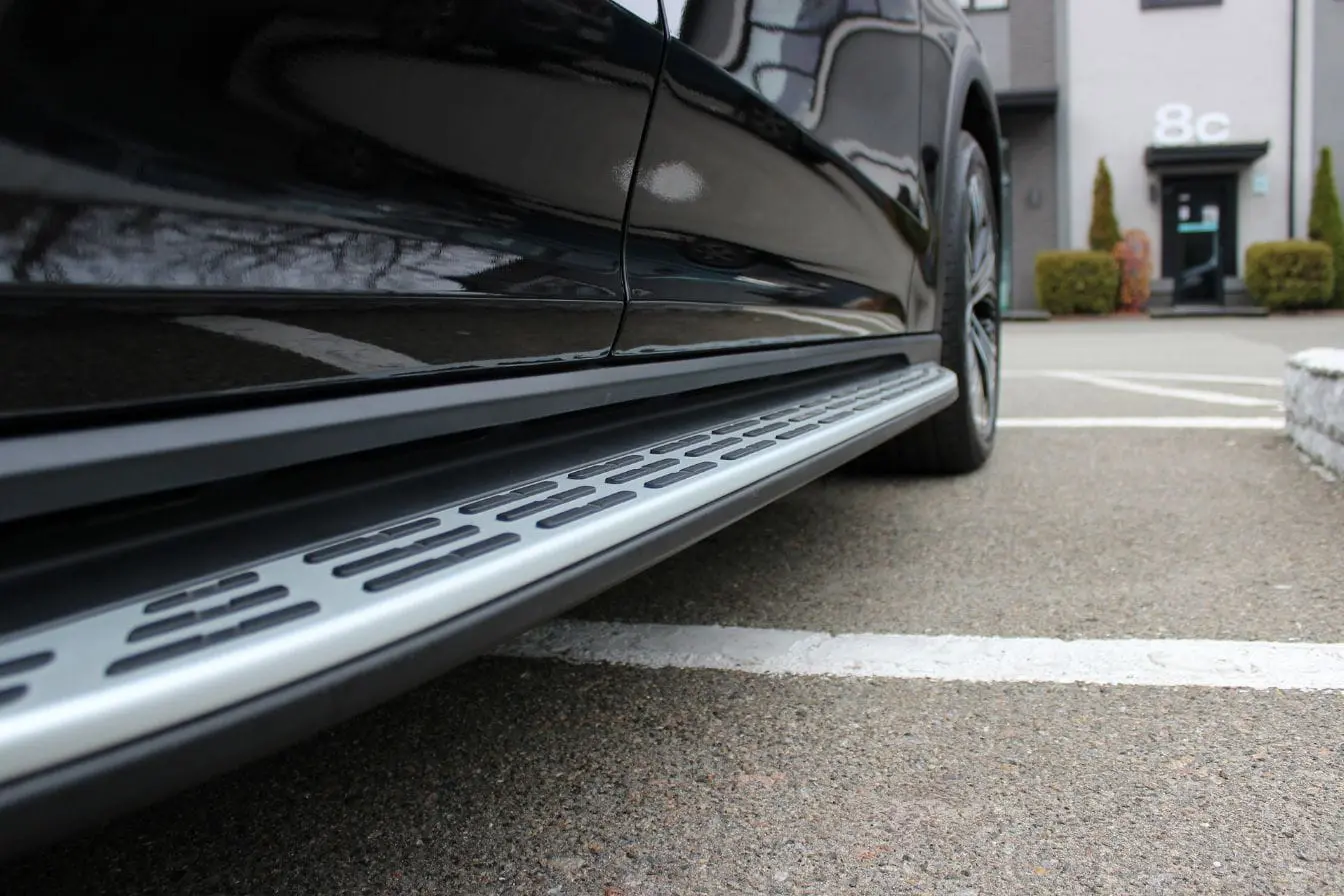 marche-pied électrique Gros plan sur marche-pied électrique installé sur SUV noir, conçu pour faciliter l’accès au véhicule avec confort et sécurité.