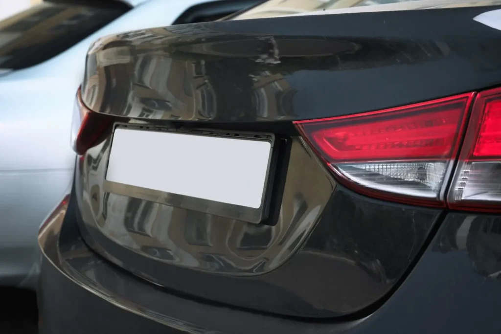 Arrière d’une voiture sombre avec plaque masquée illustrant l’usage d’un cache-plaque d’immatriculation amovible pour dissimulation temporaire