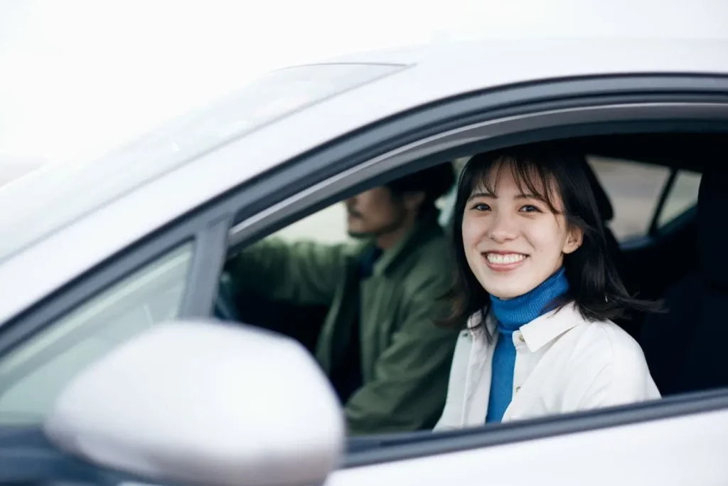 Deux personnes assises dans une voiture, conducteur concentré et passager souriant, image illustrant formation routière pour récupérer ses points de permi