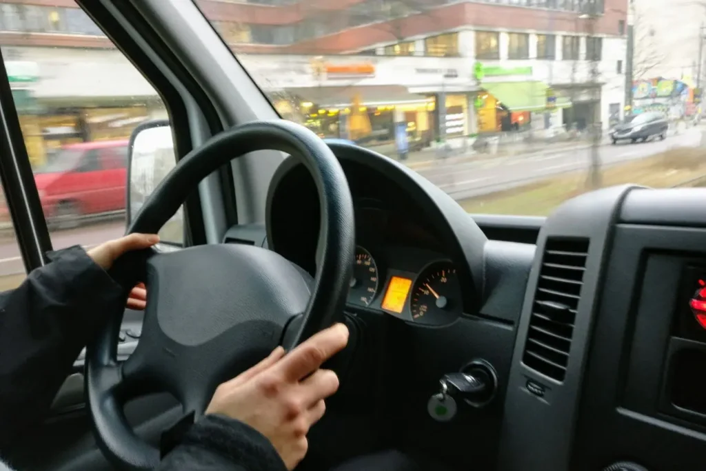 Vue intérieure d’un véhicule en mouvement avec conducteur concentré, symbole de la formation et de la récupération des points de permis.