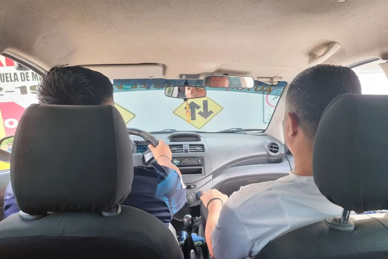 récupérer ses points de permis de conduire Intérieur de voiture avec élève au volant et moniteur à côté, image illustrant formation pratique pour récupérer ses points de permis de conduire.