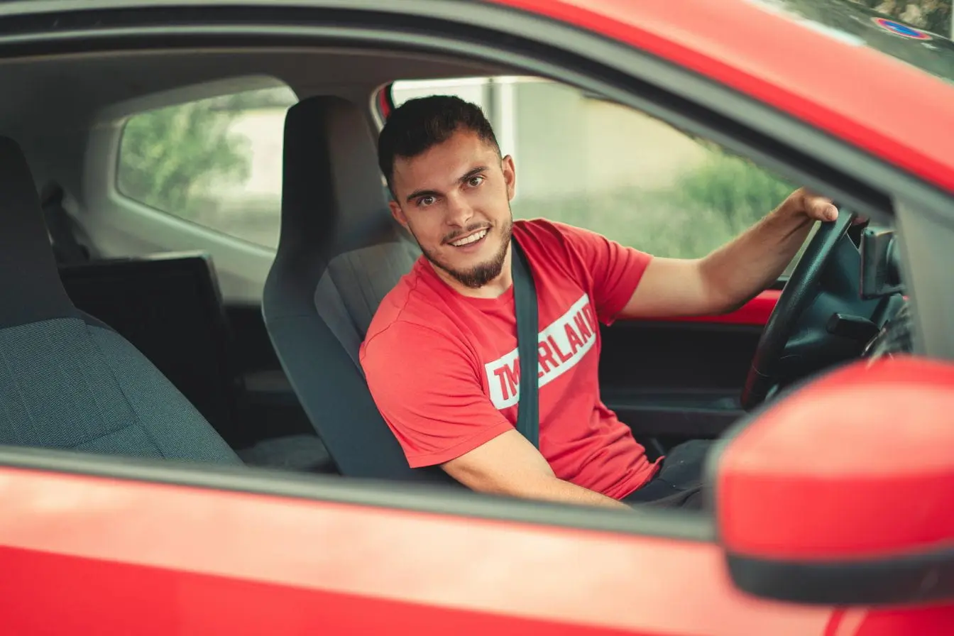 Conducteur Conducteur en tenue décontractée au volant, image évoquant le permis de conduire international et la conduite transfrontalière.
