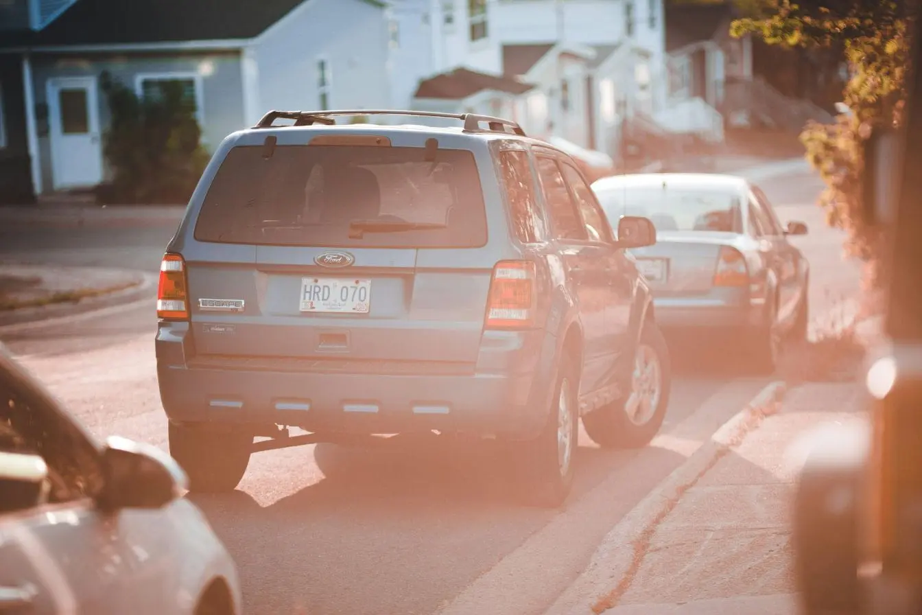 Voiture SUV bleu garé sur une rue résidentielle, image évoquant le stationnement sur trottoir qui gêne la circulation piétonne et compromet la sécurité.