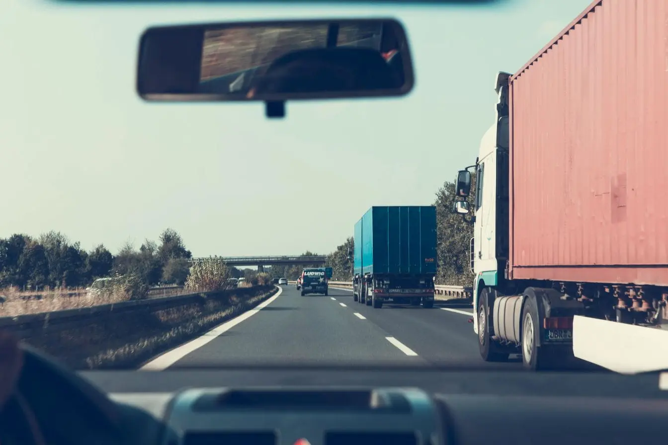 autoroute Vue depuis un véhicule sur autoroute avec camions visibles, image évoquant l’importance de respecter la distance de sécurité pour éviter collisions.