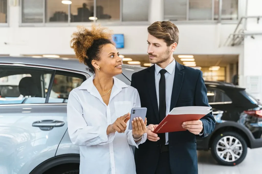 Discussion entre acheteur et vendeur reflétant financement auto et engagement contractuel.