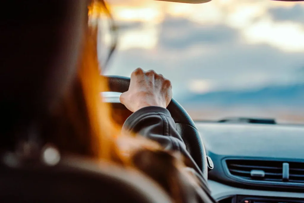 Conducteur profitant du paysage au volant, symbole d’un achat de voiture d’occasion qui permet de voyager sereinement.