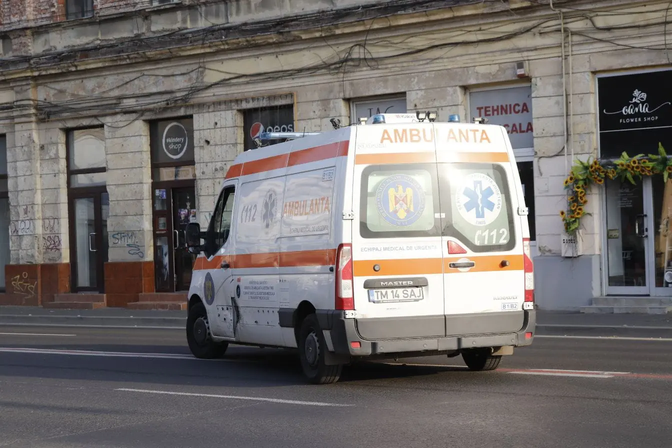 Véhicule d’urgence Ambulance blanche avec bandes orange circulant en ville, image qui illustre les obligations légales liées aux véhicules prioritaires.