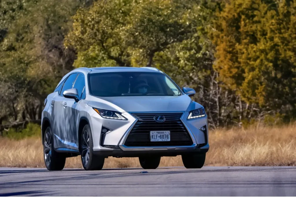 SUV argenté roulant sur route bordée d’arbres, reflet des enjeux liés au carburant HVO diesel vert et son impact environnemental.