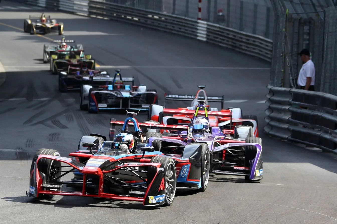 Formule 1 Voitures de course électriques en compétition sur circuit urbain, reflet des grandes étapes de l’évolution de la Formule 1.