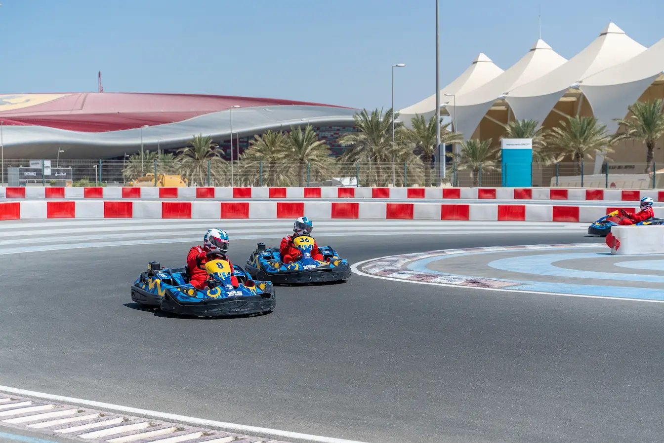 circuit automobile Trois pilotes en combinaison rouge sur karts bleus lancés sur piste, image qui illustre le circuit automobile le plus rapide du monde.