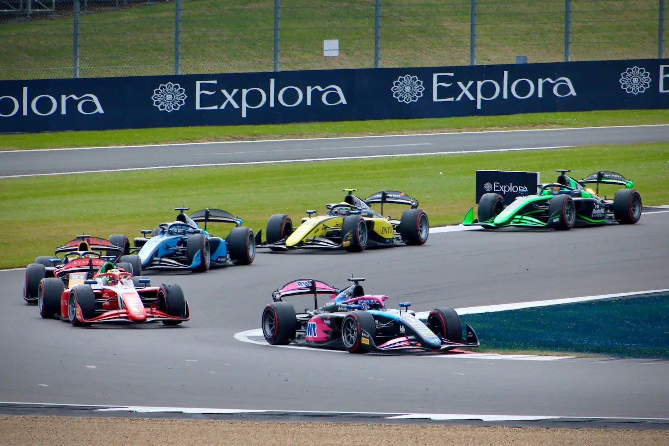 monoplaces Groupe de monoplaces colorées serrées dans virage, reflet de l’évolution du règlement technique en F1.